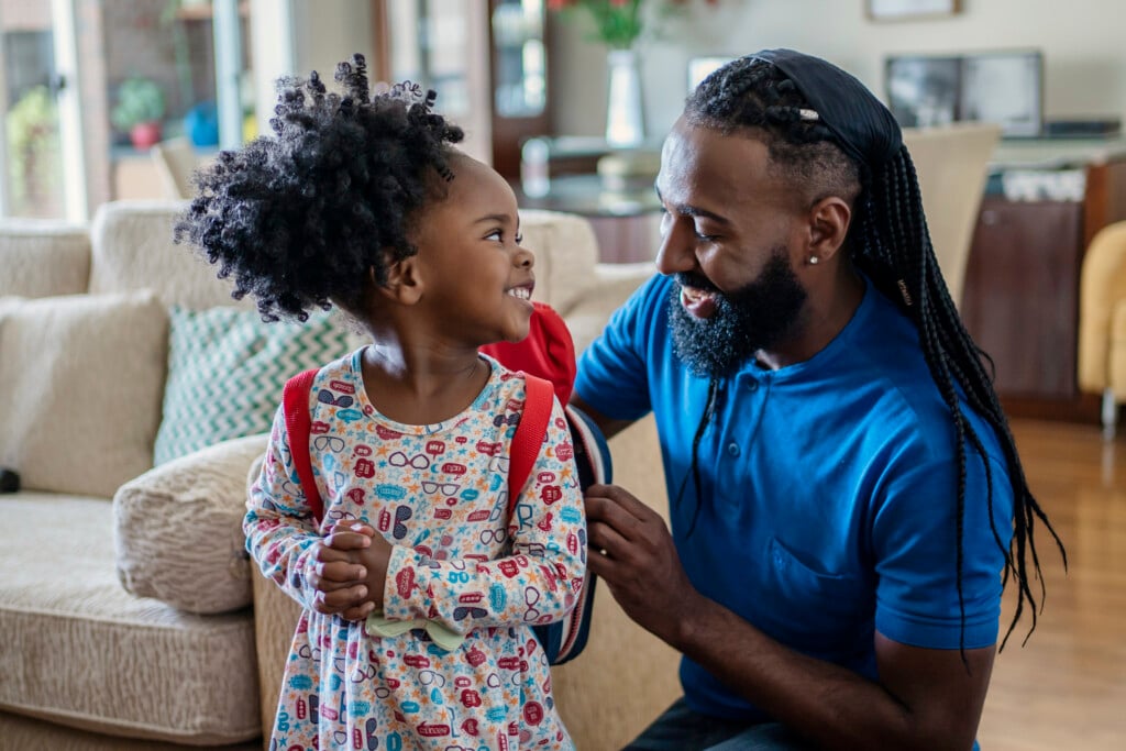 Father helping daughter get ready for school, for an article on kindergarten readiness