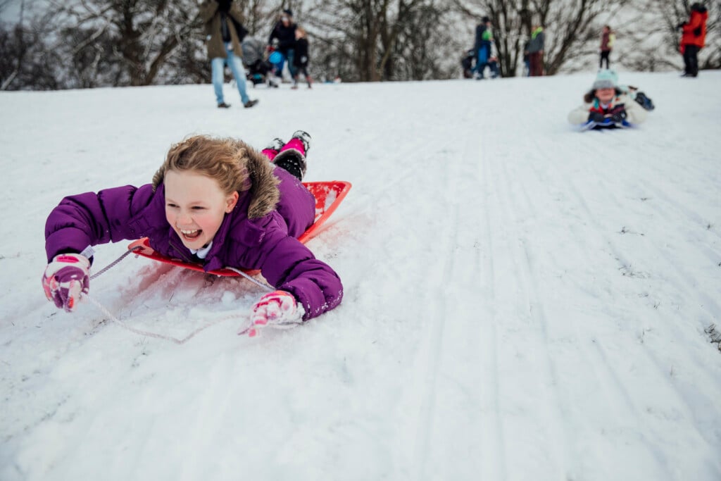 a girl sledding down a hill