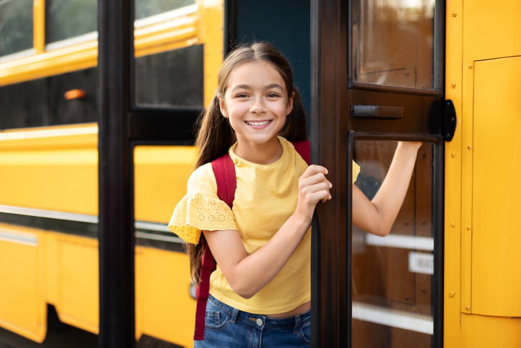 girl getting on school bus