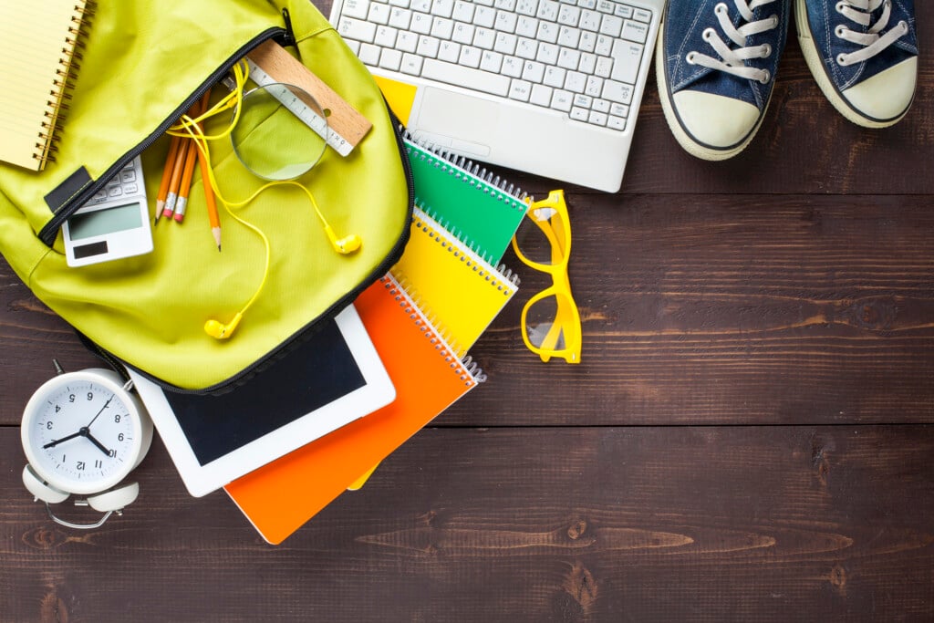 School Backpack And School Supplies On Wooden Background, for article on backpack bans