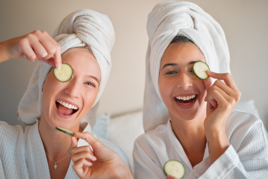 two teenage girls with spa attire and cucumber slices, smiling, skincare for teens concept