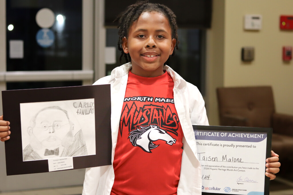 Taisen Malone holds his winning art entry and certificate
