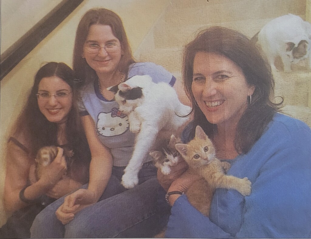 Diane Morrow-Kondos and her two daughters with three foster cats