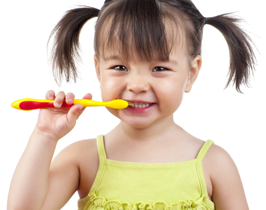 A Little Girl With Pigtails Brushing Her Teeth