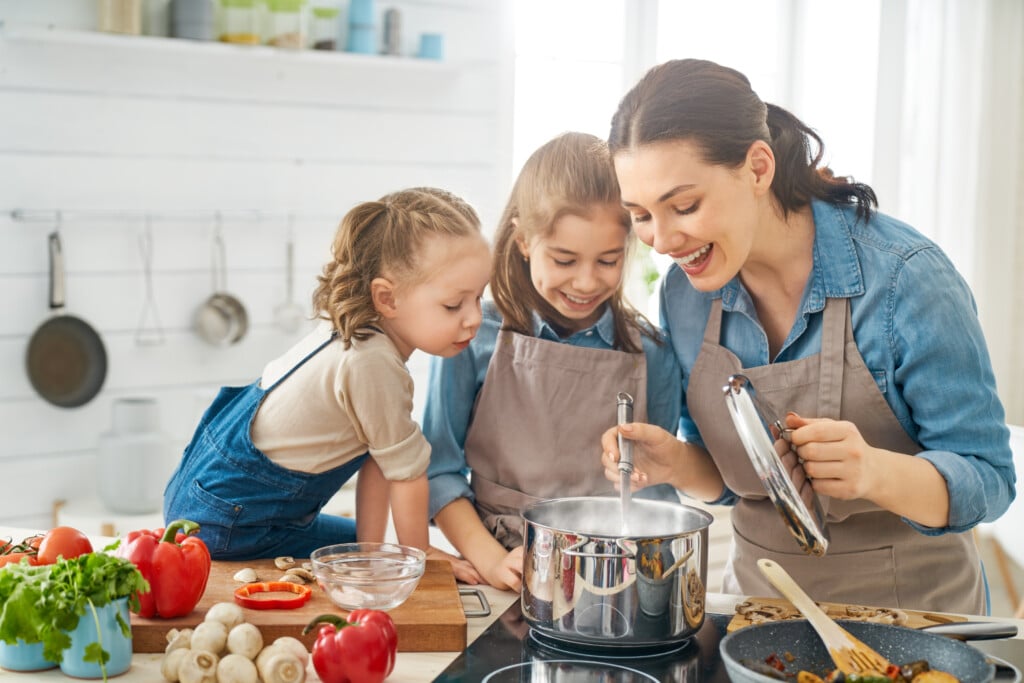 Mom and two kids cooking together at home