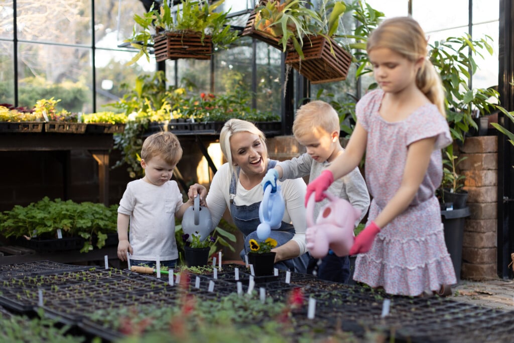 a mom gardening with her three kids