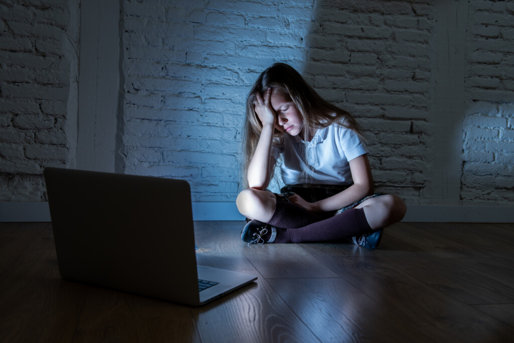 Sad Young Girl With Laptop Suffering Bullying And Harassment Online
