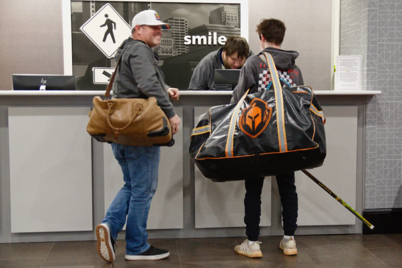 Oklahoma City high school hockey player Brent Bailey, right, and his father, Bill Bailey, check into an Olathe, Kanas, Hampton Inn in February.
