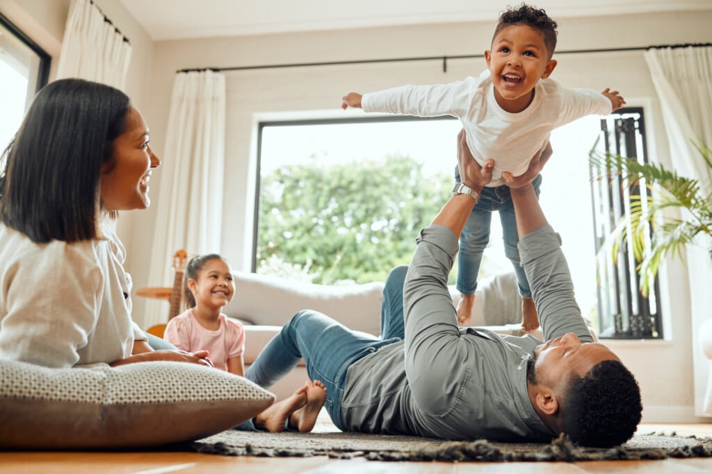 young family playing together in living room