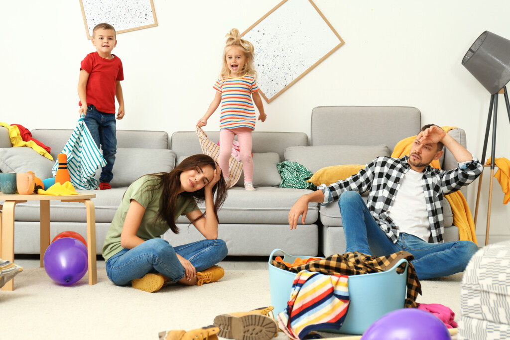 Frustrated Parents And Their Mischievous Children In Messy Room