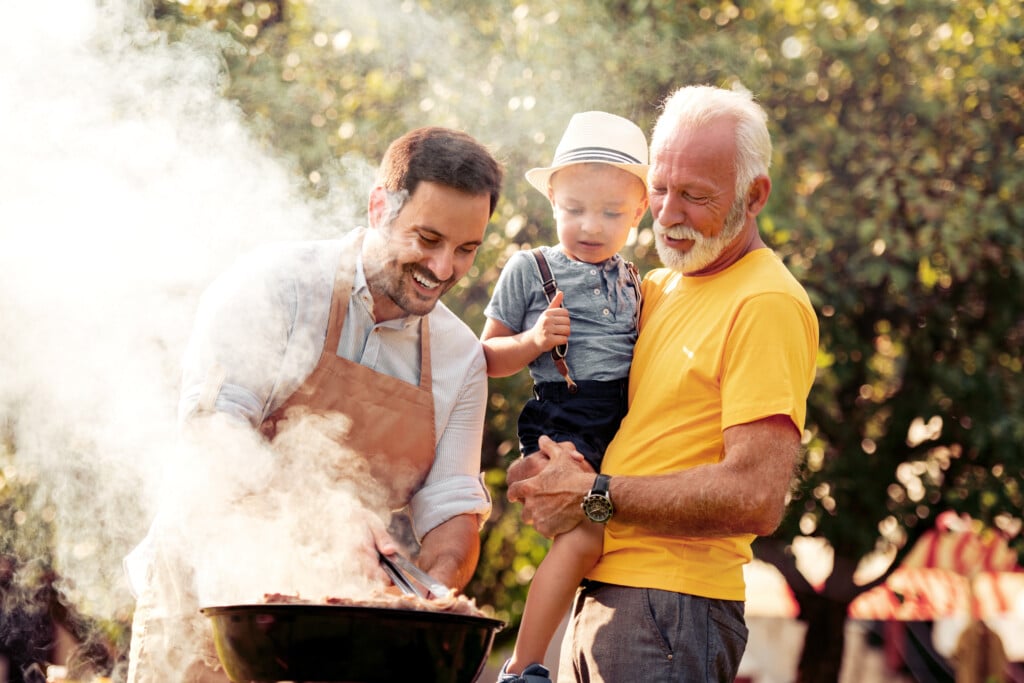three generations of men at a backyard barbecue