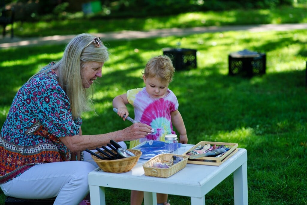 a caretaker and a toddler playing in the Philbrook gardens