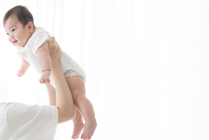 mom holding up baby
