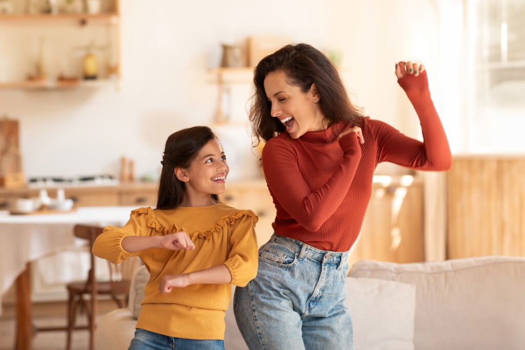 Mother And Daughter Dancing At Home