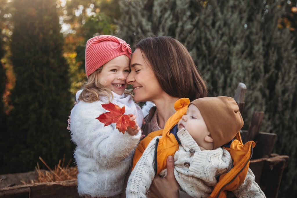 mom and young children enjoying a cozy fall morning outdoors