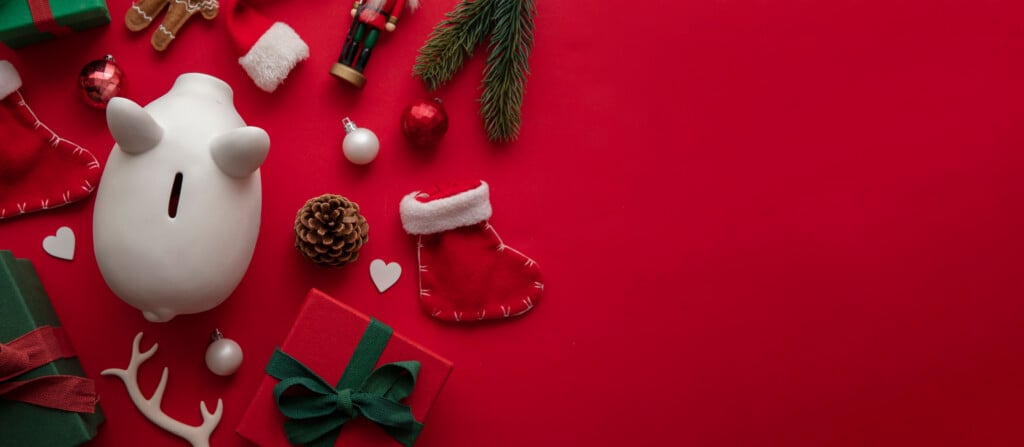 Festive Christmas Financial Savings Concept. White Piggy Bank Money Box With Presents And Decorations