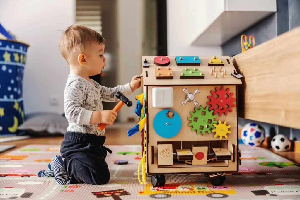 toddler playing with a wooden cube