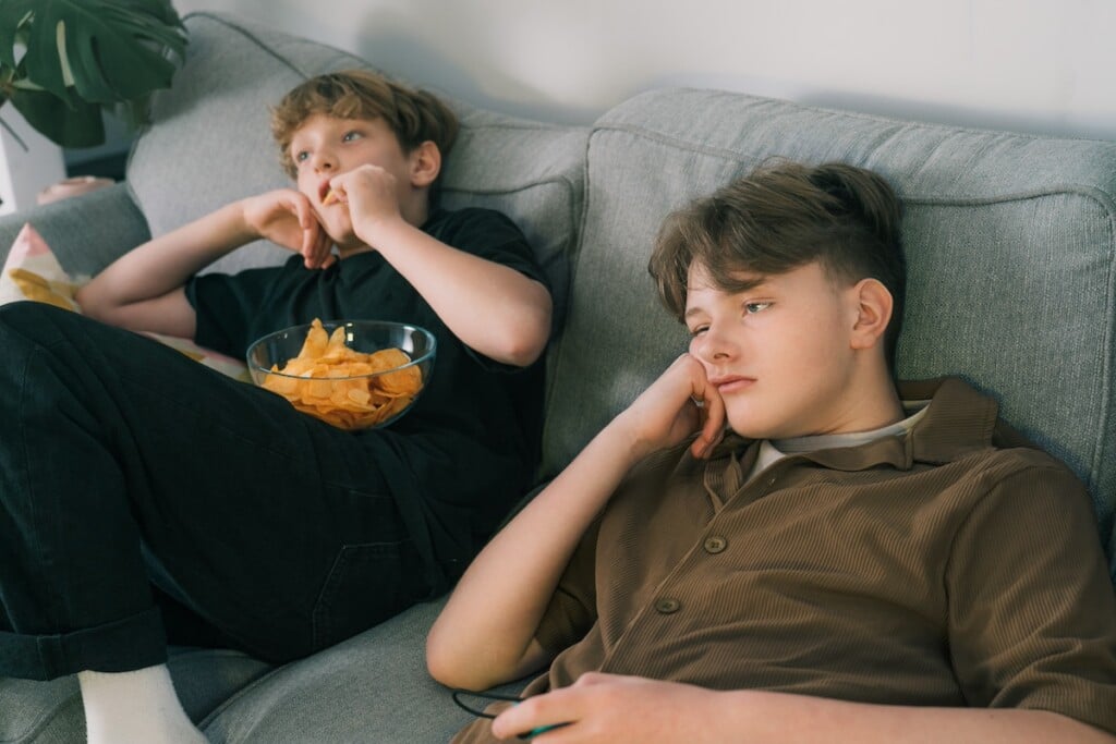 two bored teens on sofa
