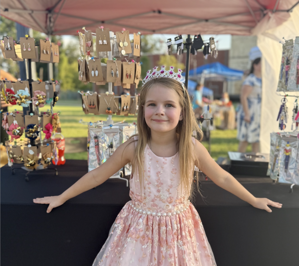 a young girl in a princess dress at a market booth