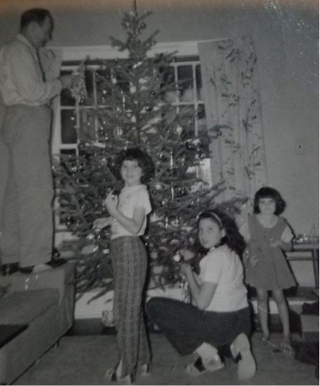 a black and white photo of children around a Christmas tree