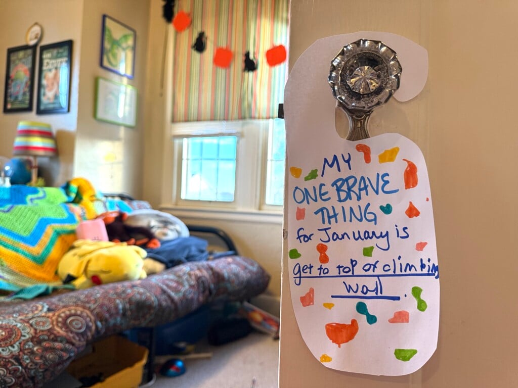 a door hanger reading My One Brave Thing for January is get to the top of climbing wall