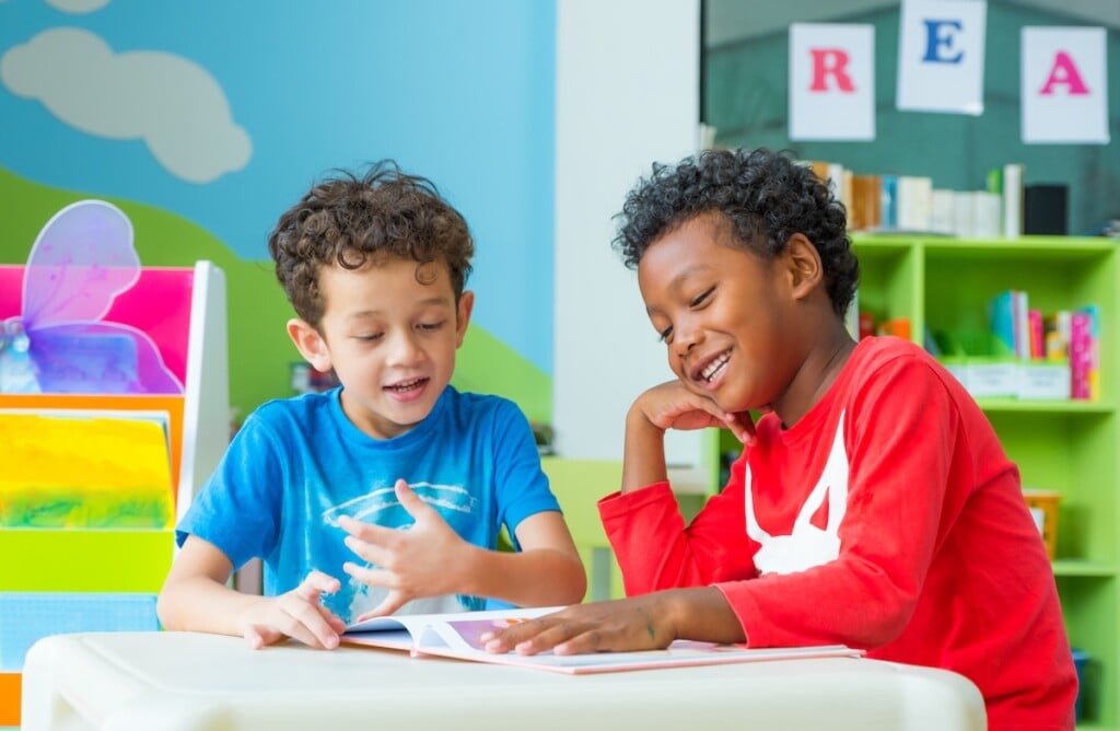 Two boys reading together in classroom