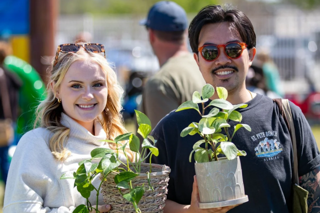 two people holding plants at Owasso Spring Fling