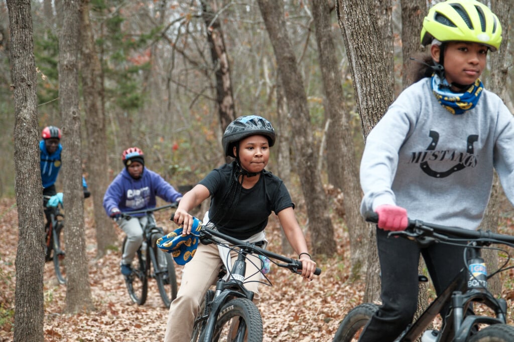 Kids in Bike Club riding on wooded trails