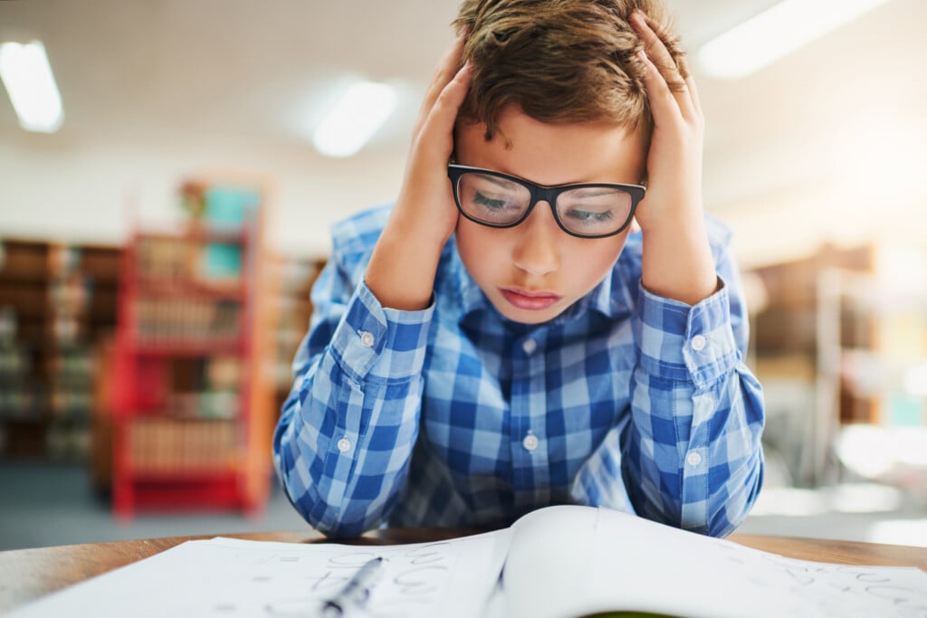 elementary aged boy in classroom looking stressed