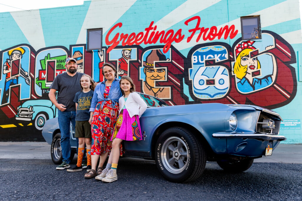 Shane Bevel and family in front of Route 66 mural and blue mustang