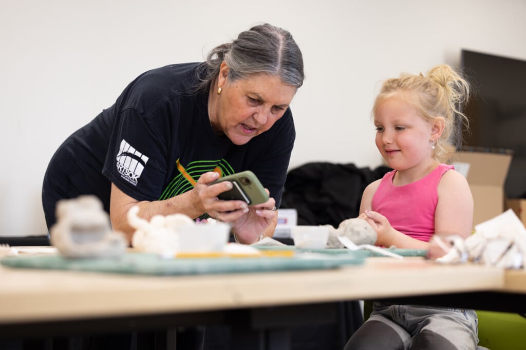 Margie Martin helps a student in her Books to Art class at Arts@302