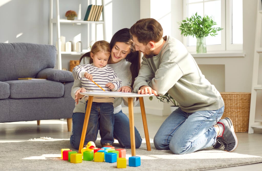 parents playing with toddler at small table