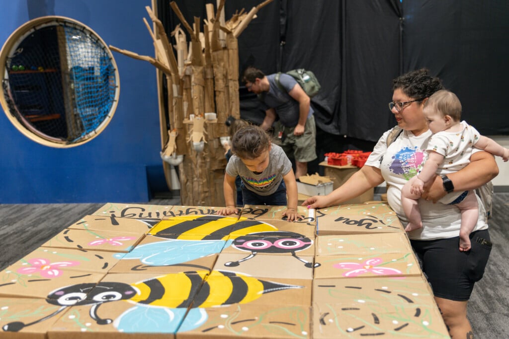a family working on a cardboard puzzle