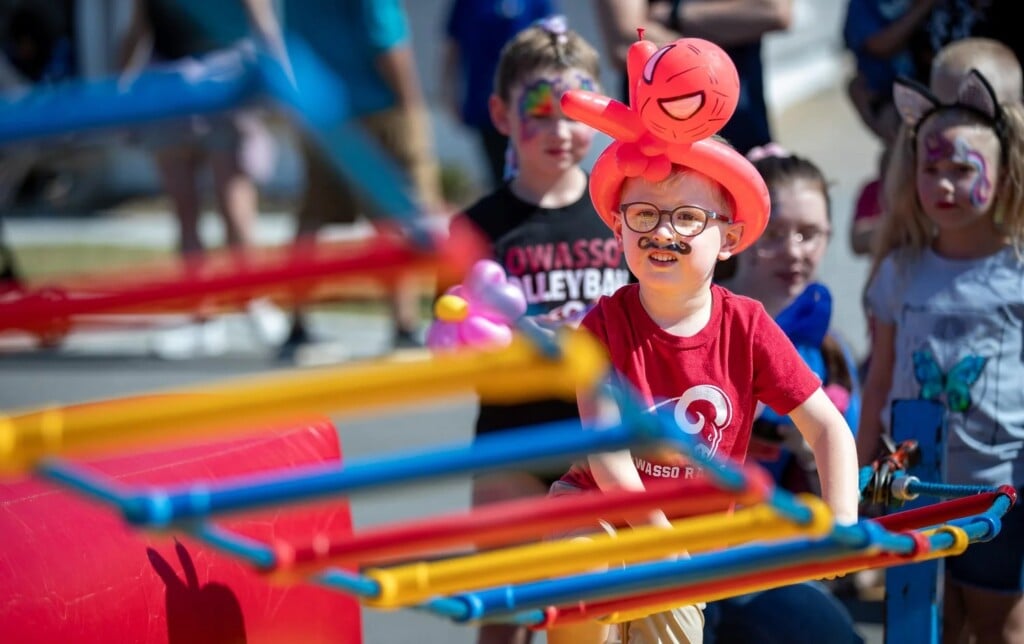 a child with fake moustache and spider-man balloon hat at the owasso harvest festival