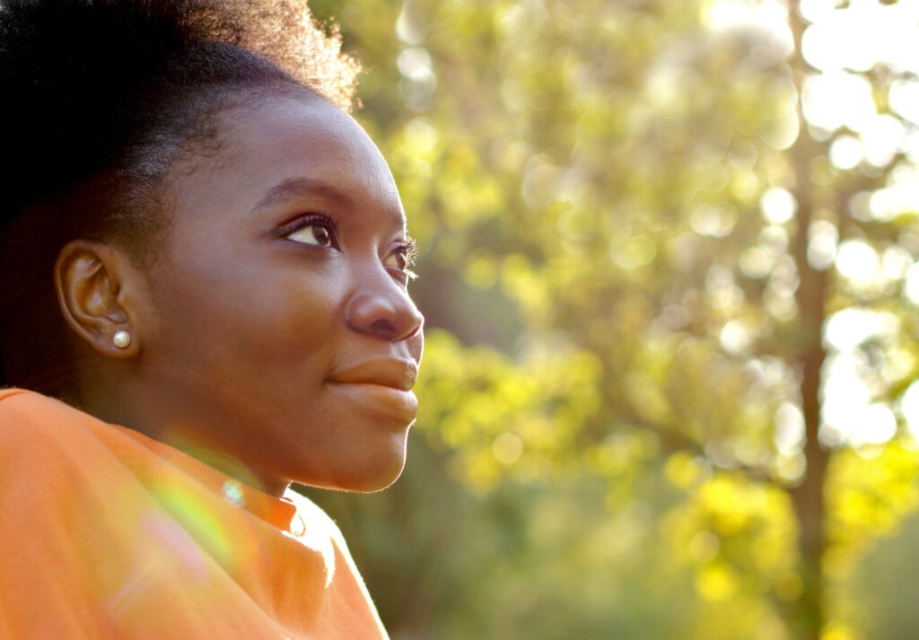 a teen smiling and observing in nature