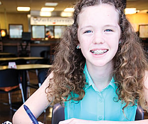 tess fineran smiling and holding a pen