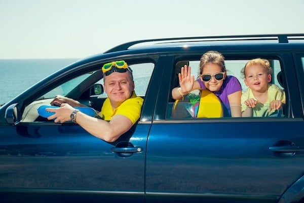 mom with two kids in a car, for article on travel tips for single parents