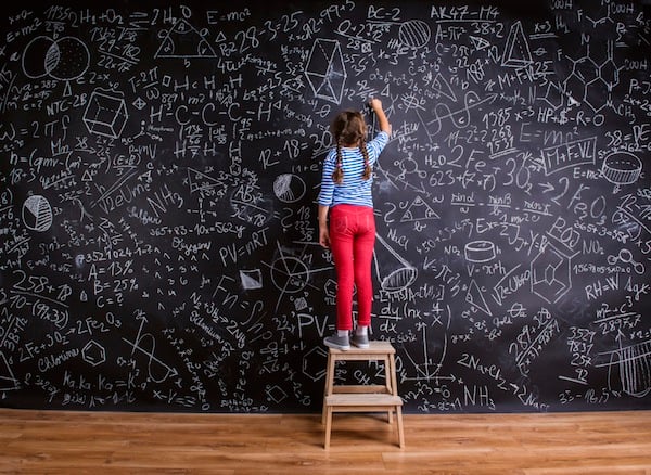 girl doing complex calculations on a chalk board, for article on math brain drain