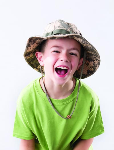 boy in nature hat and green tshirt, for article on choosing a camp