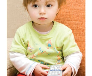 child holding electronic device, for article on secondhand tv