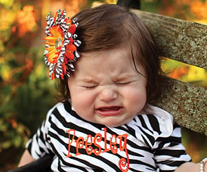 a toddler dressed for a photo session cries. toddler tantrums concept