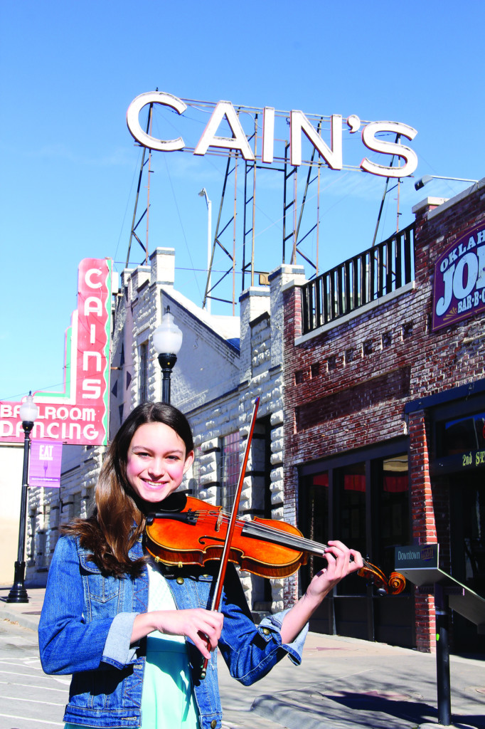 regina scott with her fiddle in front of cain's ballroom