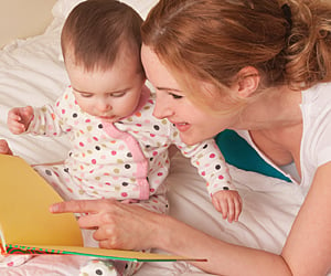 mom reads book to baby, reading to your infant concept
