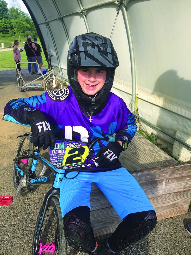 andrew kirby rests on his bmx bike