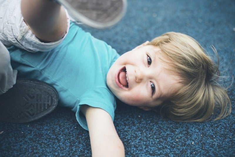a smiling toddler looking up from the floor. for our list of activities for toddlers in tulsa