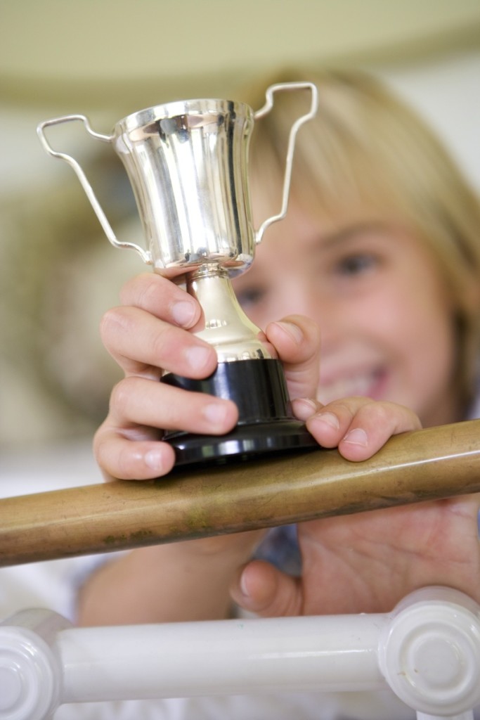 kid with small trophy, for article on developing self-esteem
