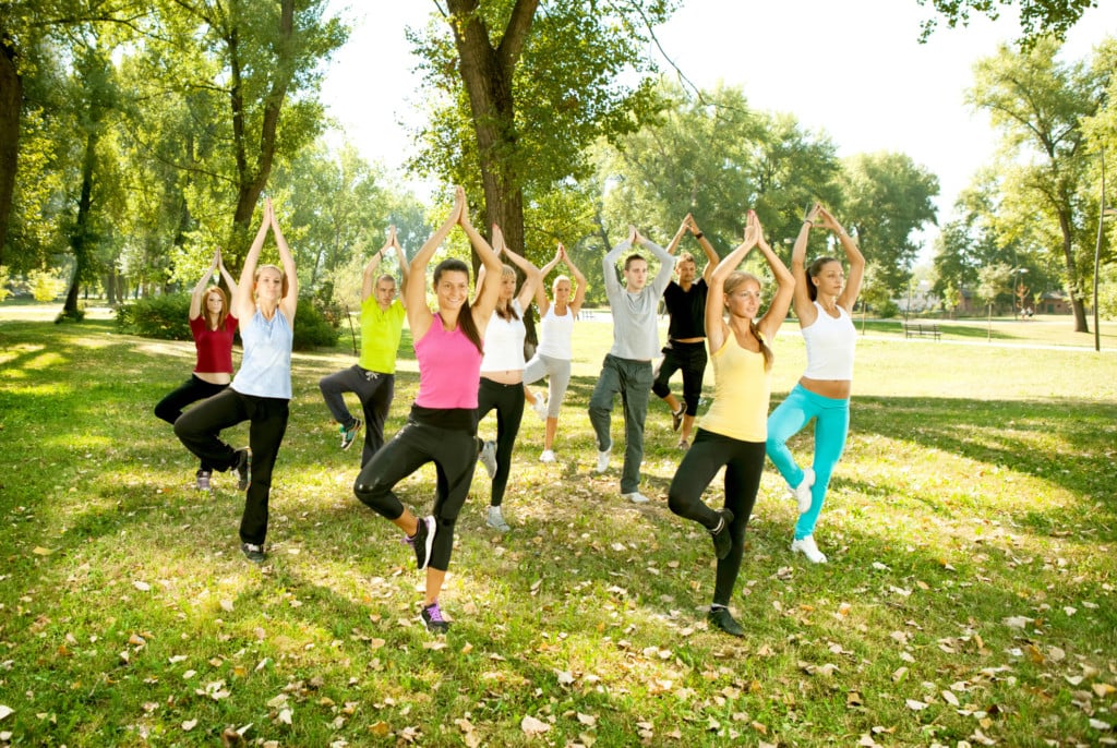 a group of young people doing yoga in a park, for article on humble warrior collective