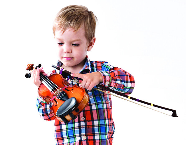 a young boy holding a violin