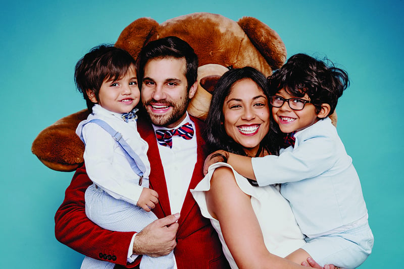 symon hajjar and his family in front of a large teddy bear