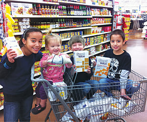 smiling kids with shopping cart, for article on how to save money on groceries